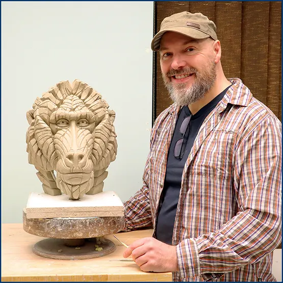 Matt Buckley with a Mandrill sculpture in clay