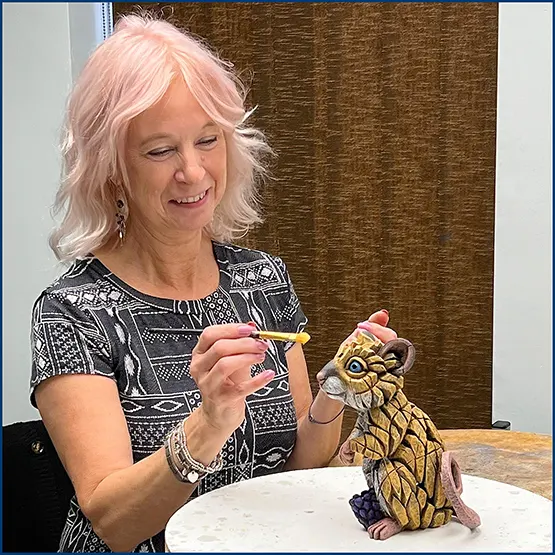 Carole Appleby applying paint to a Field Mouse sculpture