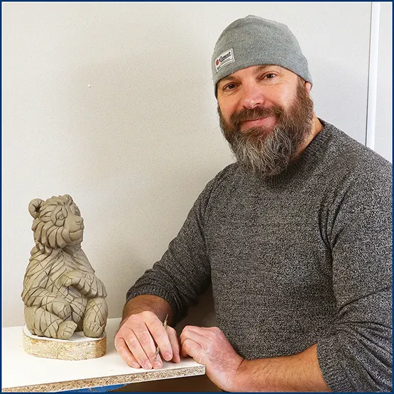 Matt Buckley with a Brown Bear Cub sculpture in clay