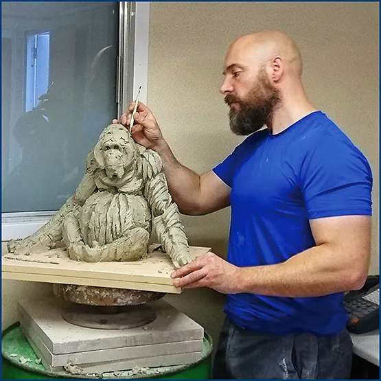 Matt Buckley working on a sitting Orangutan sculpture in clay