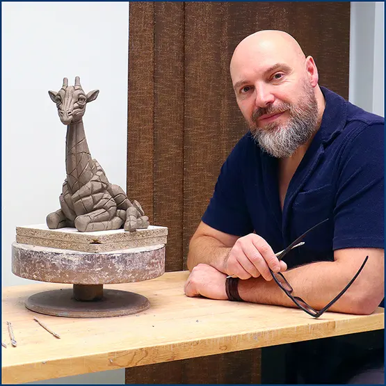 Matt Buckley with a Giraffe Calf sculpture in clay