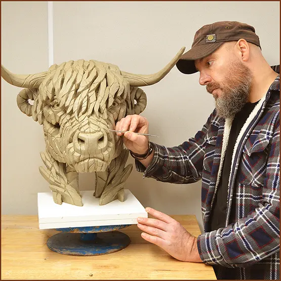 Matt Buckley sculpting a Highland Cow sculpture in clay